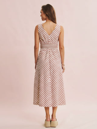 Woman wearing a striped dress on a light pink background