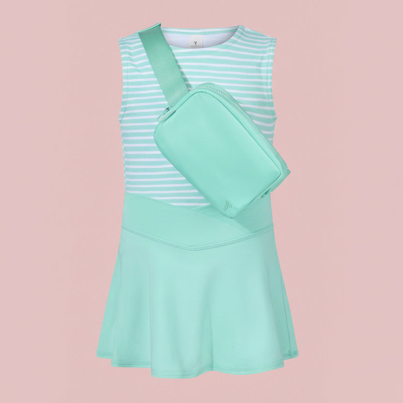 Mint green dress with a matching crossbody bag on a light pink background