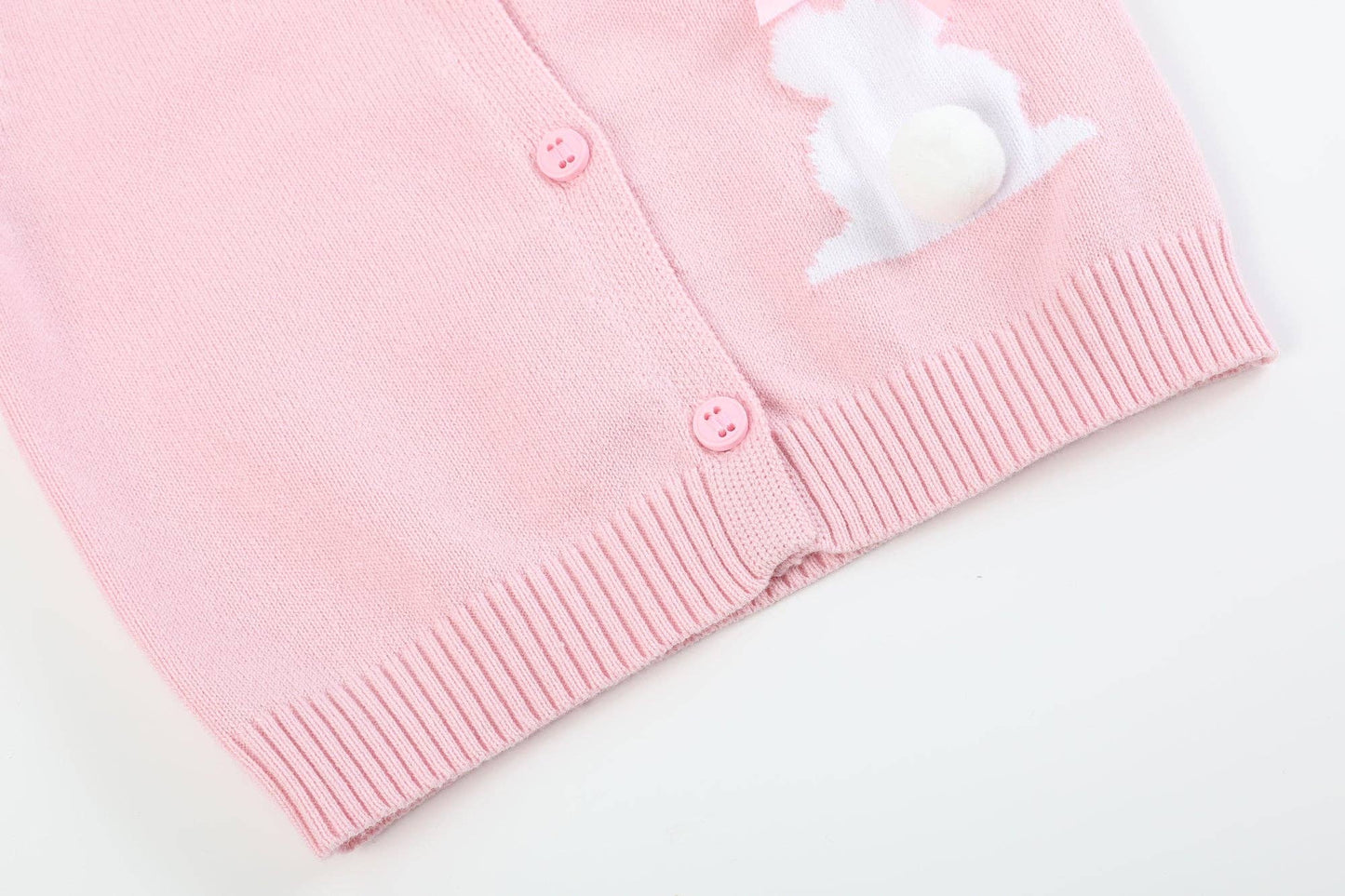 Pink cardigan with a white bunny design on a light background
