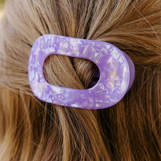 Purple hair clip with floral pattern on a person's hair