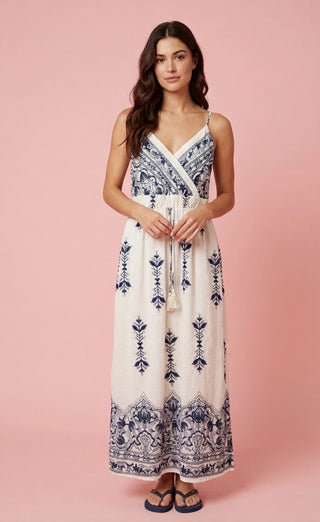 Woman wearing a white dress with blue patterns on a pink background