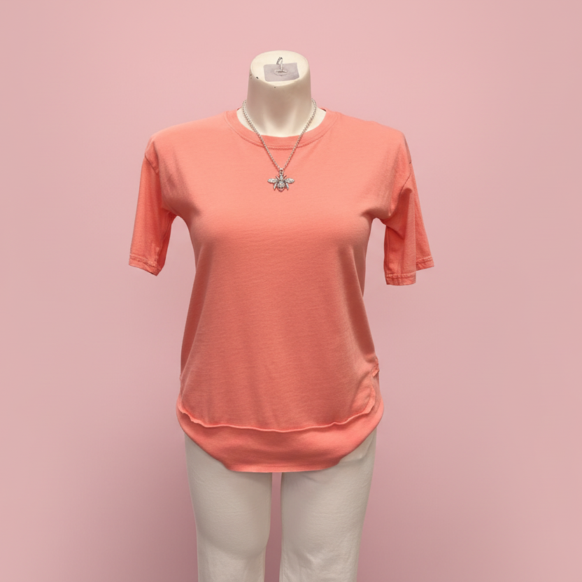 Coral t-shirt on a mannequin against a pink background