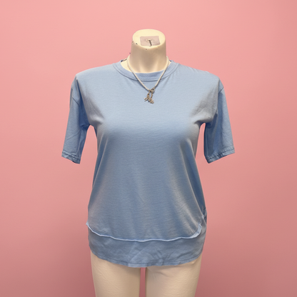 Blue t-shirt on a mannequin against a pink background