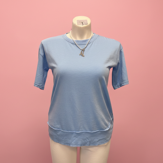 Blue t-shirt on a mannequin against a pink background