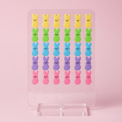 Colorful Peeps marshmallow figures arranged in rows on a pink background