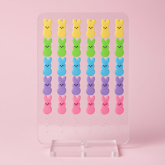 Colorful Peeps marshmallow figures arranged in rows on a pink background