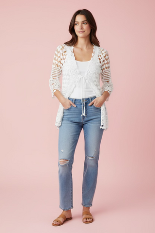 Model wearing a white lace cardigan over a white shirt 