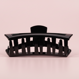 Black hair clip on a pink background