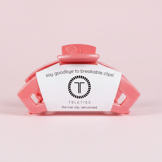 Pink hair clip with a label on a pink background