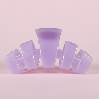 Purple hair clip on a pink background