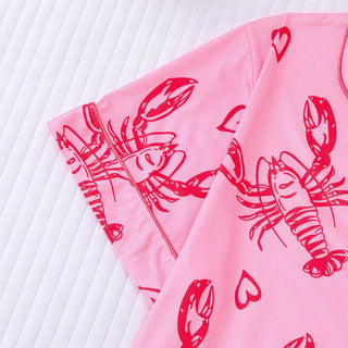 Pink fabric with red lobster and heart patterns on a white background