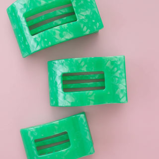 Green marbled hair clip on a pink background
