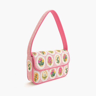 Floral patterned handbag with pink handle on a pink background