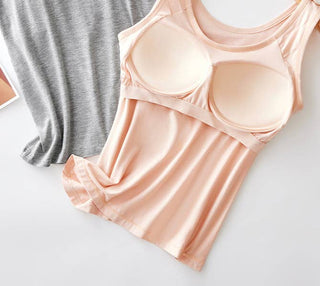 Light pink tank top with built-in bra on a white surface