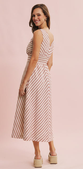 Woman wearing a striped dress on a pink background