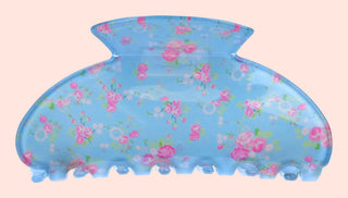 Blue floral-patterned hot water bottle on a pink background