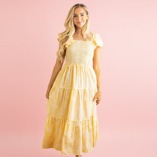 Woman wearing a yellow dress against a pink background