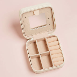 Beige jewelry case with compartments on a pink background