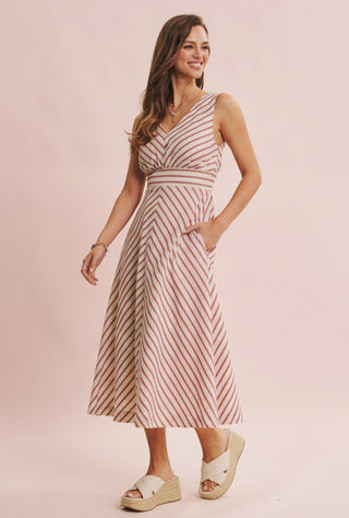 Woman wearing a striped dress on a pink background