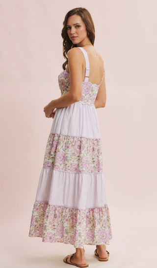 Woman wearing a floral tiered dress on a pink background