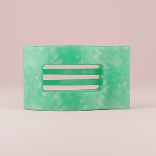 Green marbled hair clip on a pink background