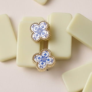 Pair of earrings with floral design on a light pink background