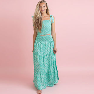 Woman wearing a green floral dress against a pink background