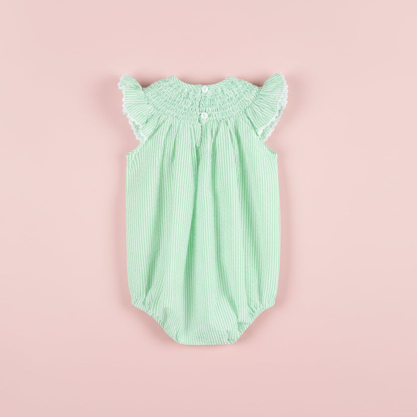 Green striped baby romper with ruffled sleeves on a pink background