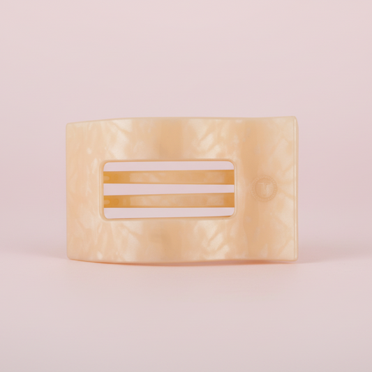 Beige hair clip on a pink background