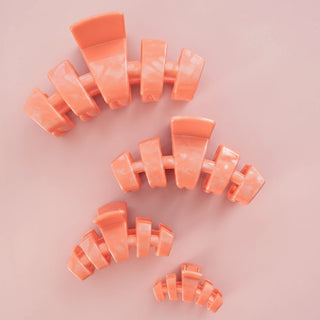 coral hair clip on a pink background