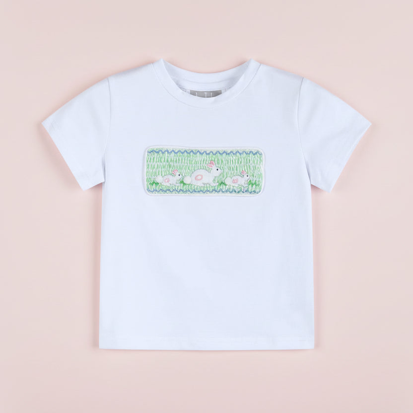 White t-shirt with a colorful graphic on a pink background